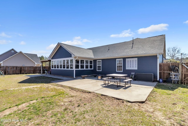 rear view of property featuring a yard, a fenced backyard, a patio, and roof with shingles