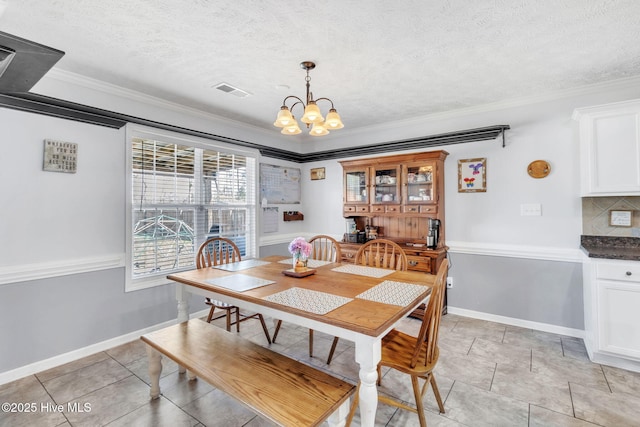 dining space featuring baseboards, a textured ceiling, an inviting chandelier, and ornamental molding