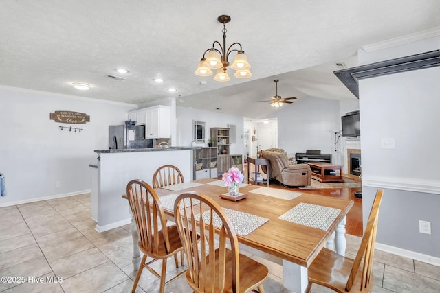 dining area featuring lofted ceiling, a textured ceiling, ornamental molding, and a ceiling fan