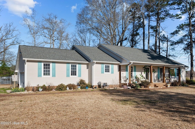 single story home featuring a porch, a front yard, and a shingled roof