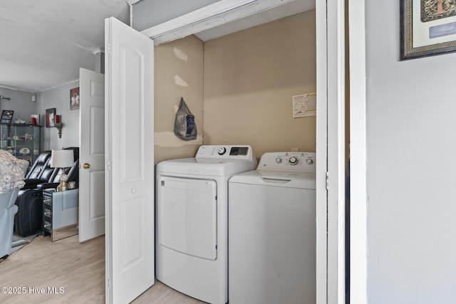 laundry area with laundry area, independent washer and dryer, and light wood-type flooring