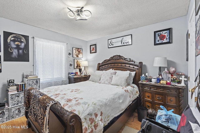 bedroom with a textured ceiling and wood finished floors