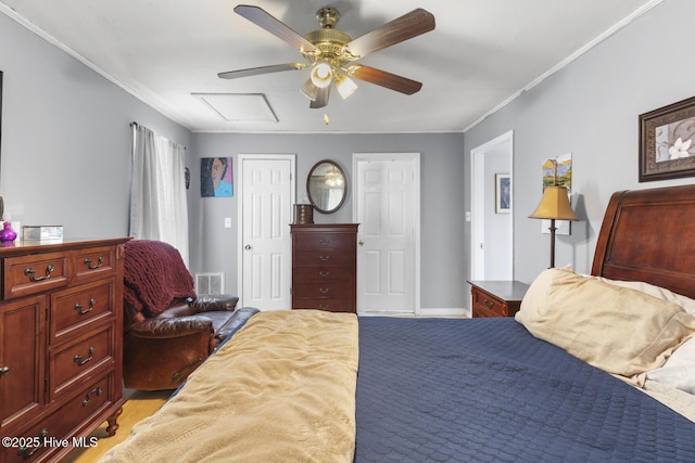 bedroom featuring visible vents, attic access, crown molding, and ceiling fan