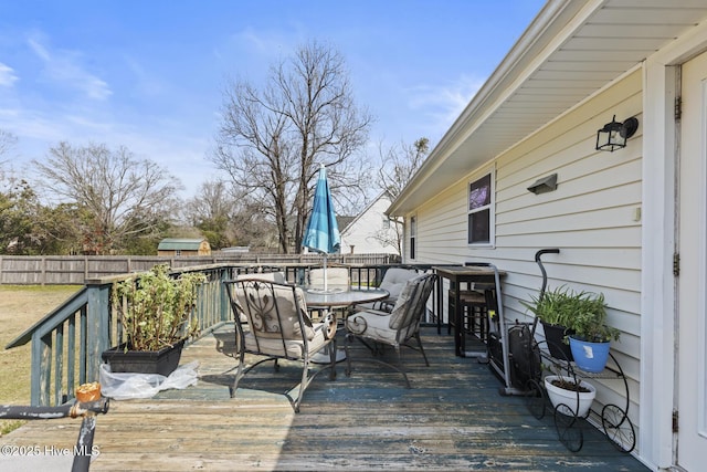 deck with outdoor dining space and fence