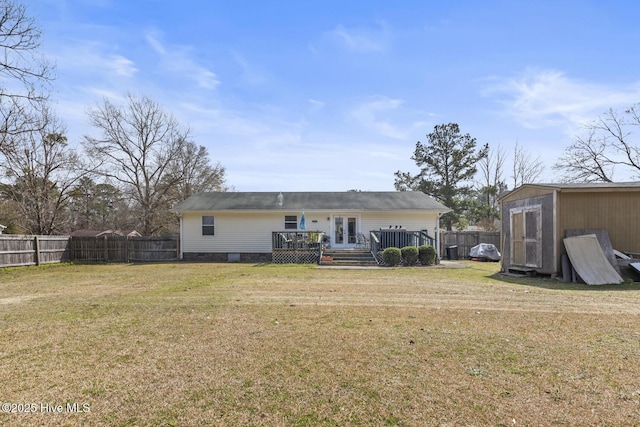 back of property with a storage shed, an outdoor structure, french doors, and a lawn