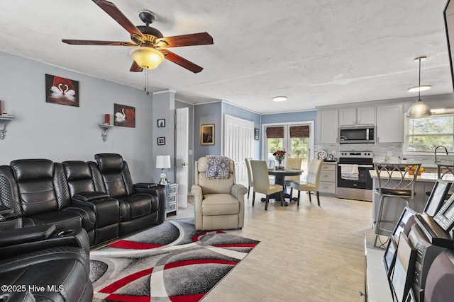 living room with light wood-style floors and a ceiling fan