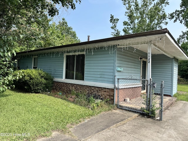 1122 E Stewart Cir, Wilmington, NC 28405 - view of side of home with a gate, a lawn, and brick siding