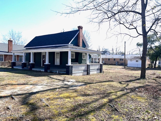 exterior space with a porch and a chimney