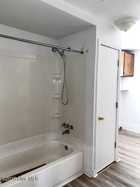 full bath with wood finished floors and bathtub / shower combination