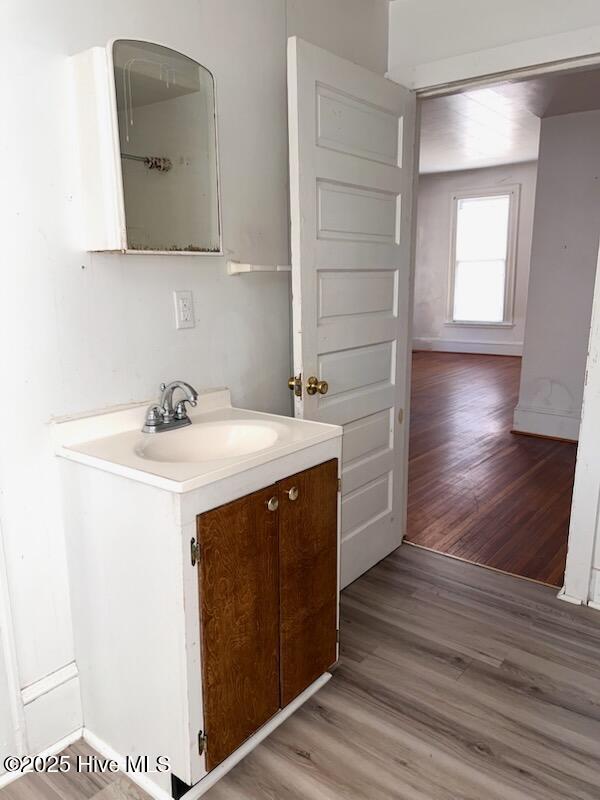 bathroom with vanity, baseboards, and wood finished floors