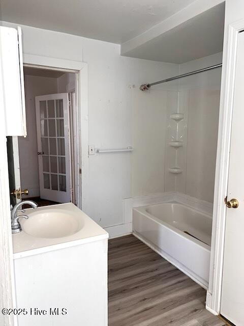 bathroom featuring shower / washtub combination, vanity, and wood finished floors