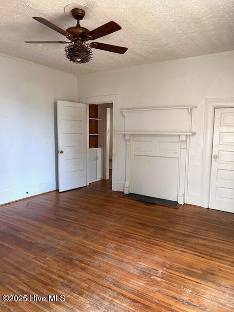 unfurnished living room with baseboards, wood-type flooring, a textured ceiling, and ceiling fan