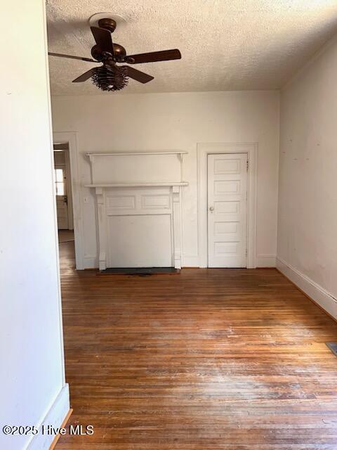 unfurnished living room with a ceiling fan, wood finished floors, and a textured ceiling