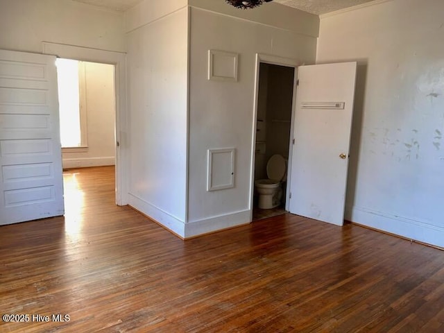 spare room with baseboards and hardwood / wood-style floors