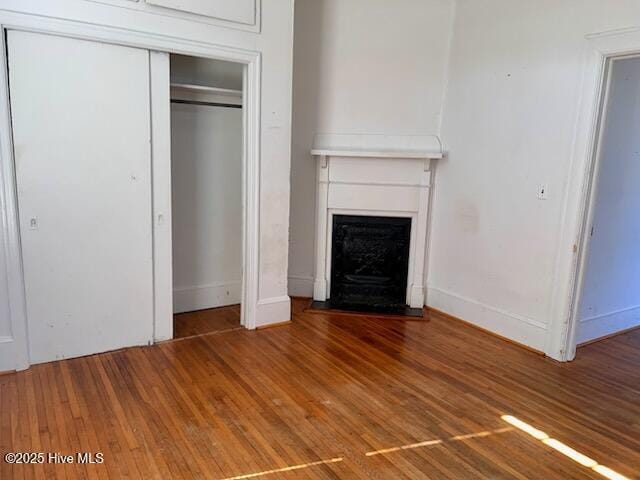 interior space featuring baseboards, wood finished floors, and a fireplace