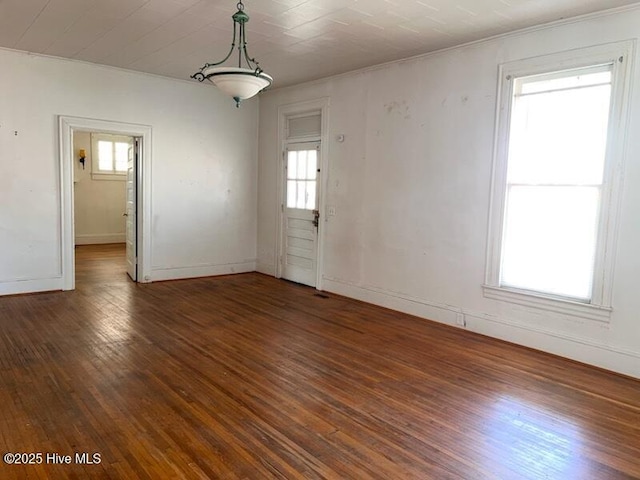 unfurnished room with a wealth of natural light, baseboards, and hardwood / wood-style flooring