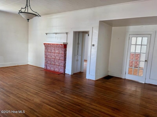 unfurnished living room featuring ornamental molding, baseboards, and wood finished floors