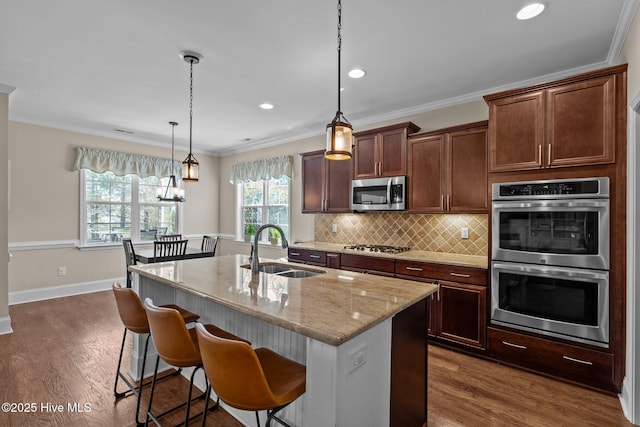 kitchen featuring a sink, tasteful backsplash, dark wood-style floors, appliances with stainless steel finishes, and crown molding