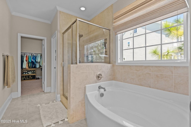 bathroom featuring a shower stall, crown molding, a walk in closet, a garden tub, and tile patterned floors