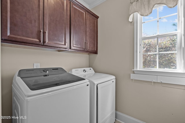 laundry room featuring crown molding, cabinet space, baseboards, and washer and clothes dryer