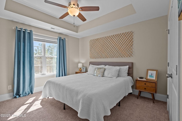 bedroom featuring visible vents, a raised ceiling, baseboards, and carpet floors