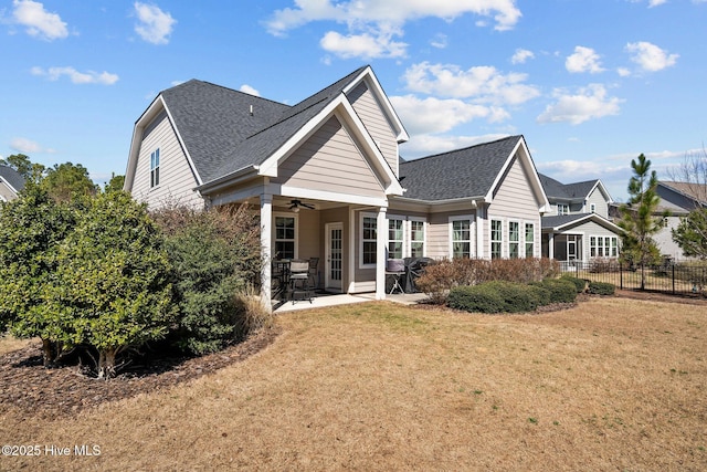 back of property featuring a ceiling fan, fence, roof with shingles, a yard, and a patio area