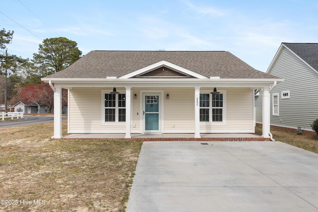 bungalow-style house featuring roof with shingles and covered porch