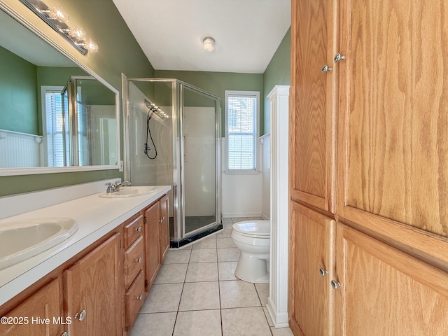 full bath featuring a sink, toilet, a shower stall, and tile patterned floors