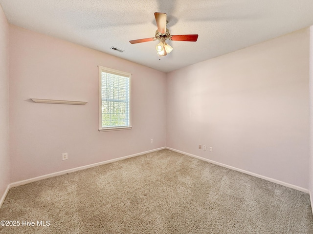 spare room featuring visible vents, baseboards, carpet, a textured ceiling, and a ceiling fan