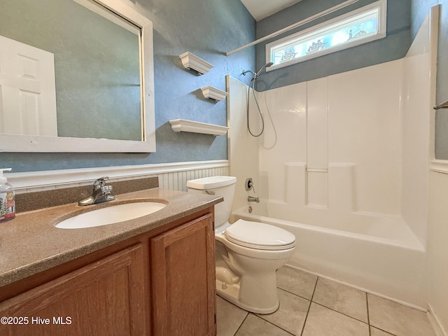 full bathroom featuring vanity, tile patterned flooring, wainscoting, shower / bathing tub combination, and toilet