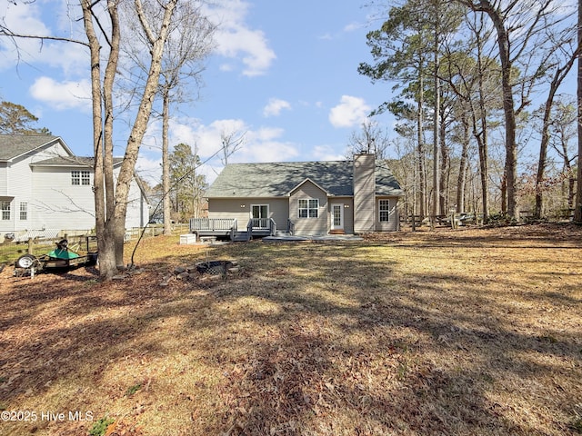 rear view of property with a deck and a chimney