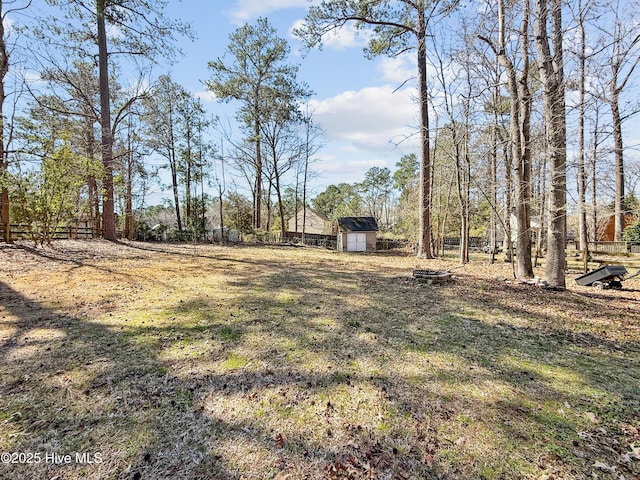 view of yard with an outdoor structure, fence, and a shed