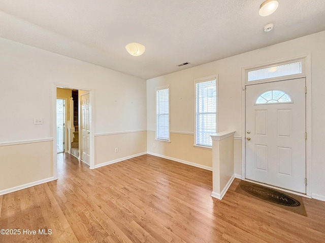 entrance foyer with visible vents, light wood-type flooring, and baseboards