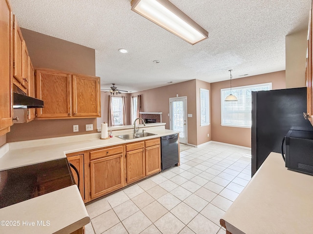 kitchen featuring a sink, black appliances, light countertops, and under cabinet range hood