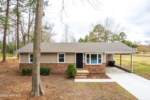 ranch-style home with brick siding, a shingled roof, a carport, concrete driveway, and crawl space