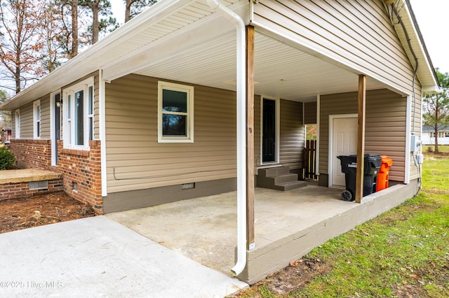 view of home's exterior featuring crawl space, an attached carport, brick siding, and entry steps