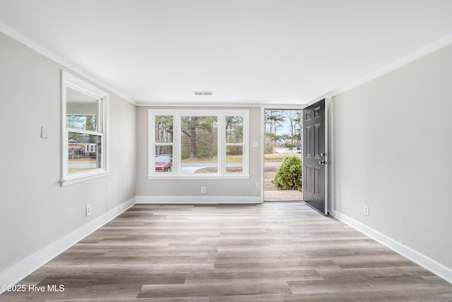 unfurnished room featuring visible vents, baseboards, and wood finished floors