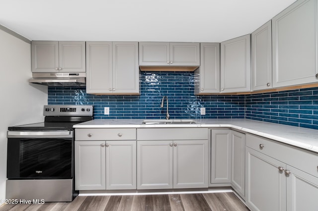 kitchen with under cabinet range hood, a sink, gray cabinets, and electric stove