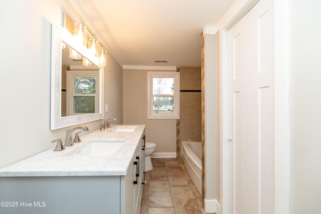 full bath with a sink, visible vents, toilet, and double vanity