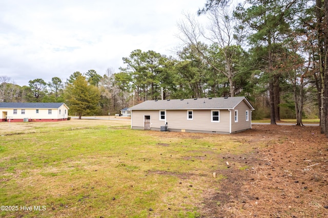 back of house featuring a yard and crawl space