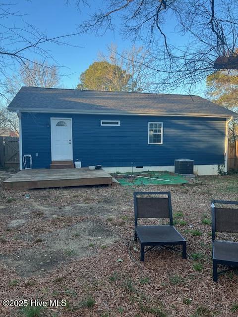 rear view of property featuring central air condition unit, a deck, and fence