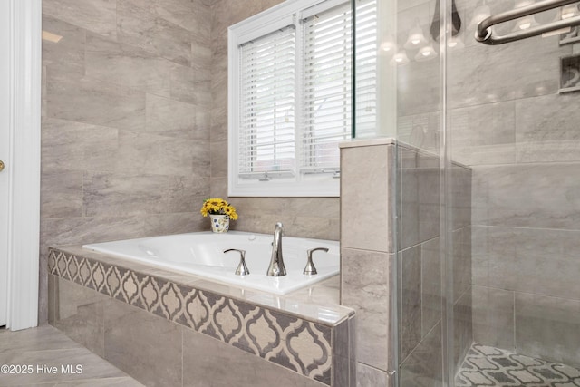 bathroom with a garden tub, tile walls, and a shower stall