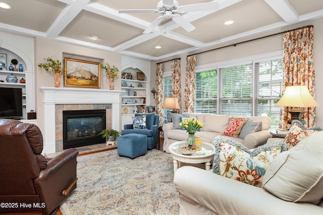 living area featuring recessed lighting, a tiled fireplace, built in features, coffered ceiling, and a ceiling fan