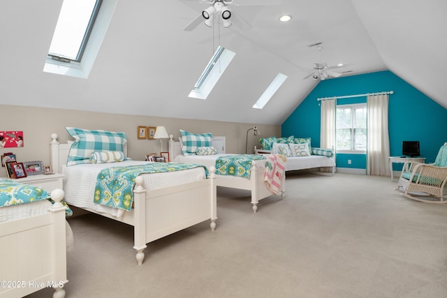 bedroom with baseboards, a ceiling fan, lofted ceiling with skylight, and carpet flooring