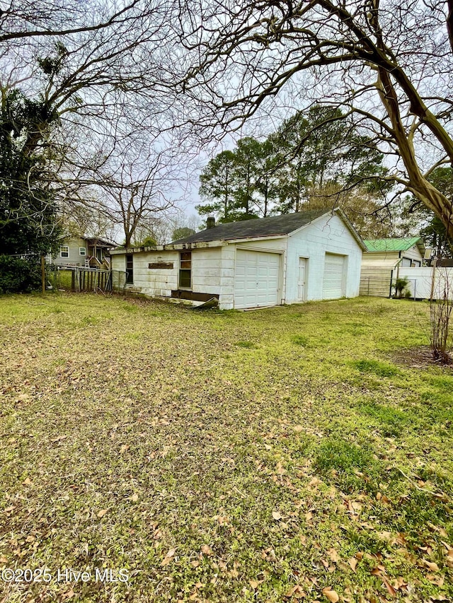 view of yard with an outbuilding, a garage, and fence