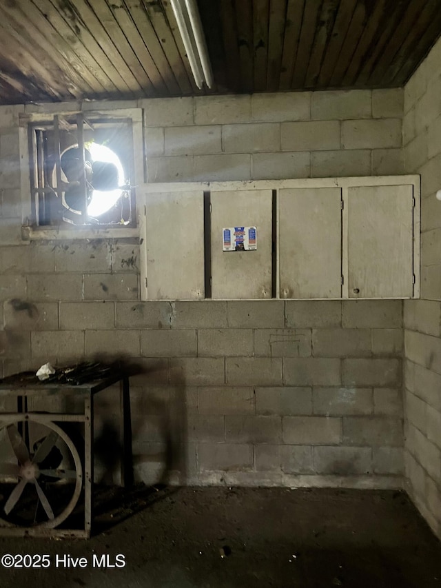 basement featuring wood ceiling and concrete block wall
