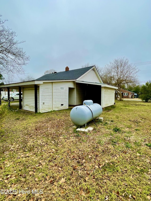 rear view of house featuring a chimney and a yard