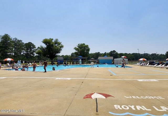 community pool featuring fence and a patio