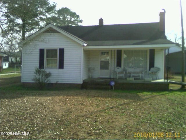 single story home with a chimney and a porch