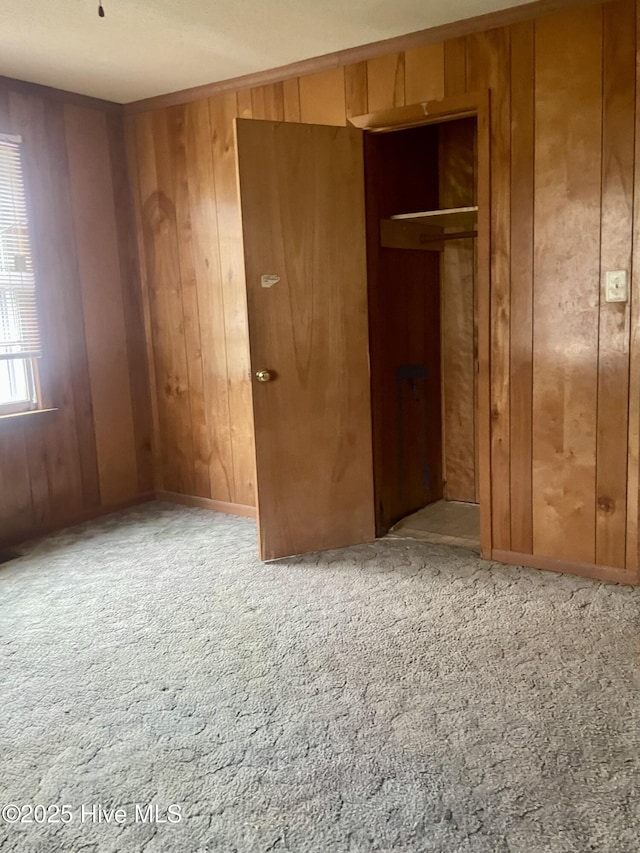 empty room with wood walls and carpet floors